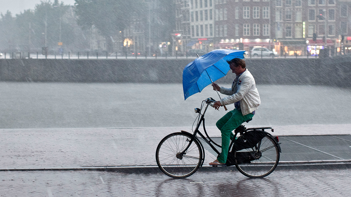 Man fietst in regen op fiets