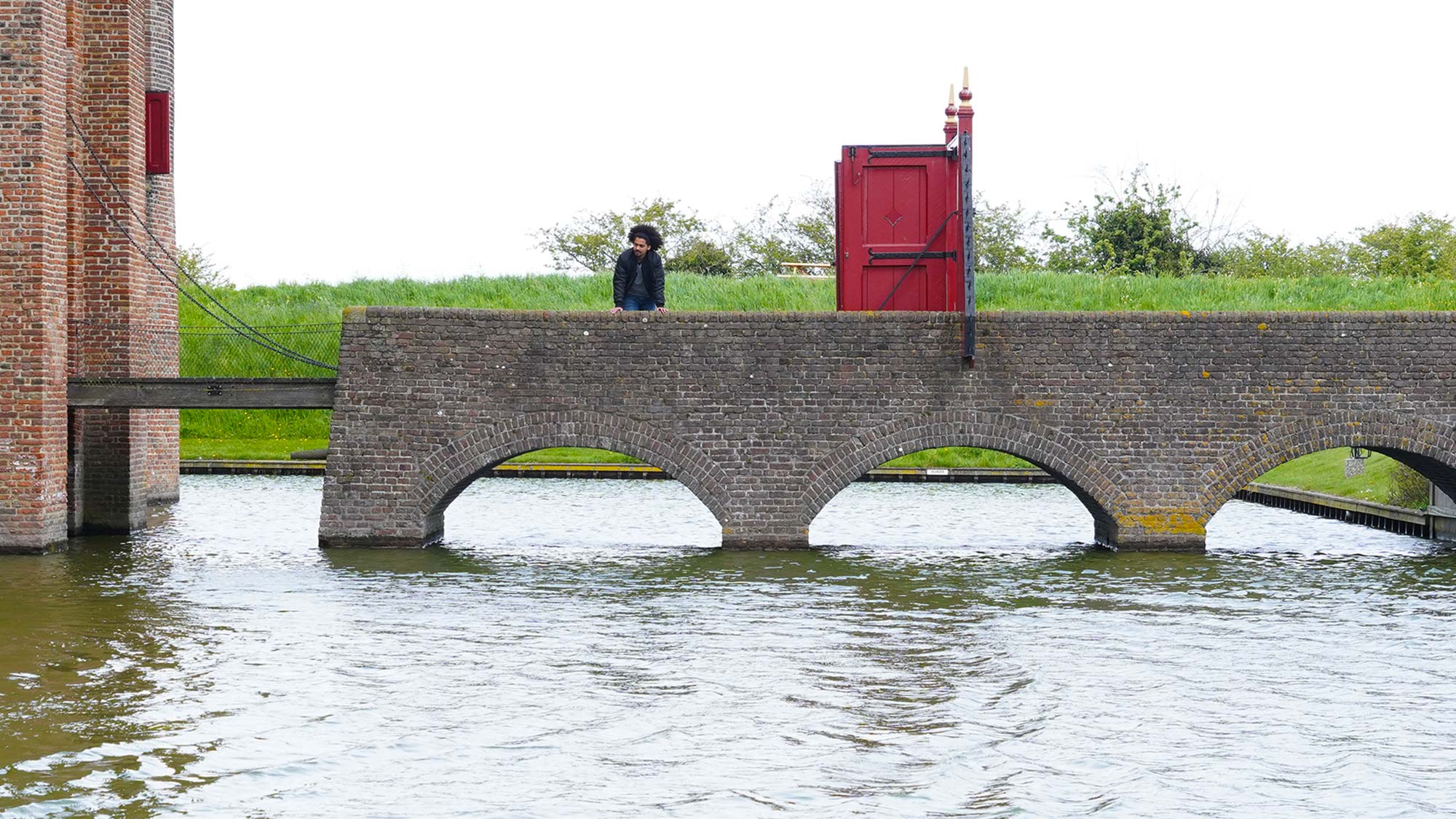 Thiëmo staat op de brug over de gracht van het Muiderslot