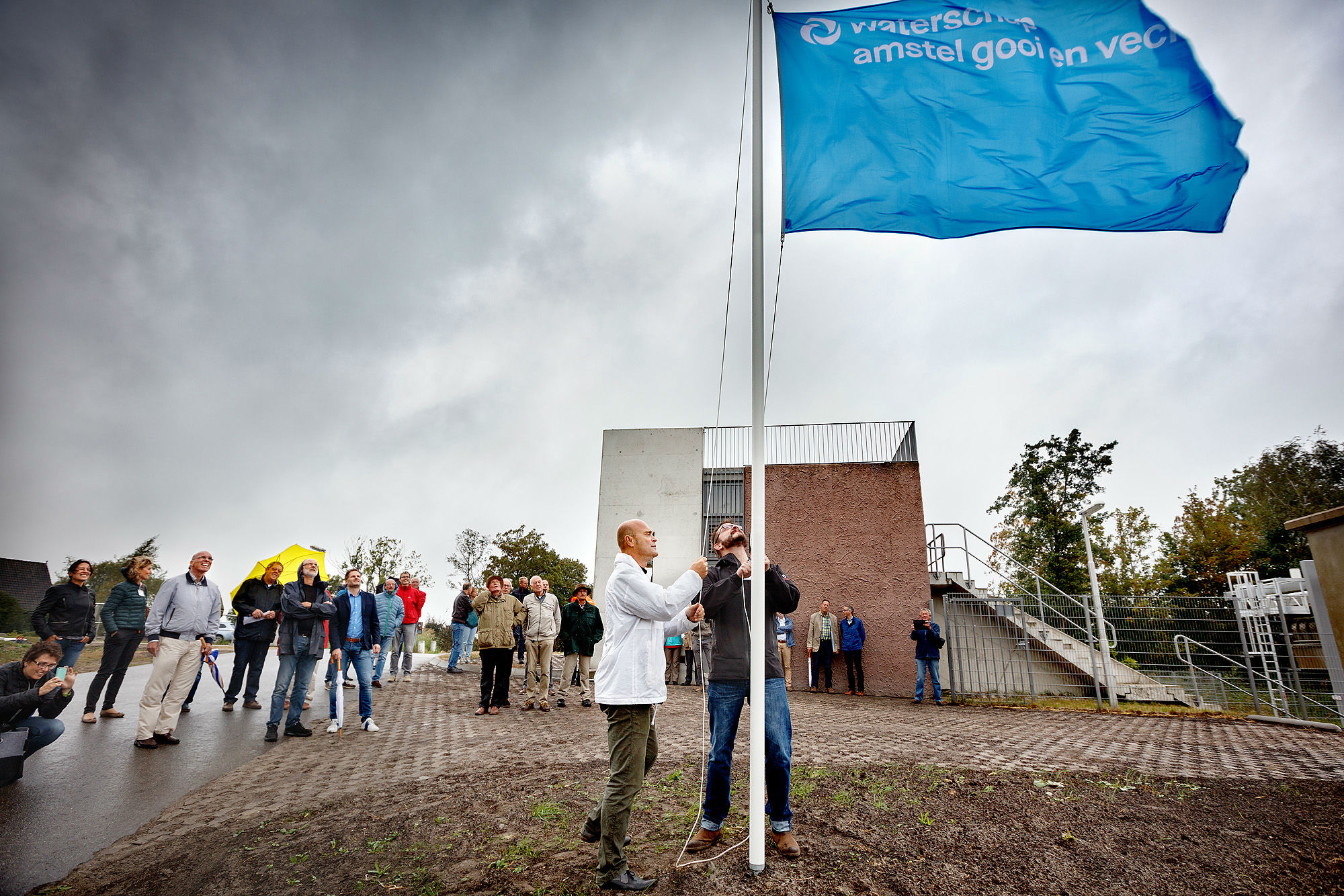 Wiegert Dulfer hijst de vlag van het Waterschap Amstel, Gooi en Vecht, en opent daarmee de visvriendelijke Dooijersluis