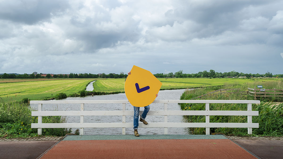 Denk Vooruit man staat op een brug bij water.jpg
