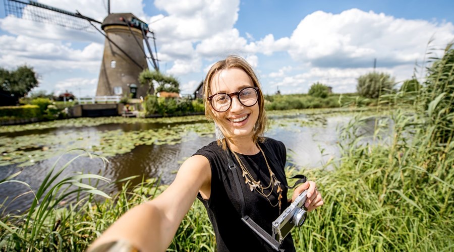 Meisje maakt selfie langs water voor molen