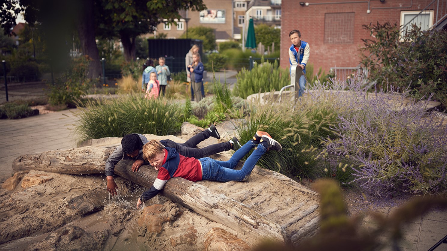 Kinderen spelen in een natuurspeeltuin met water